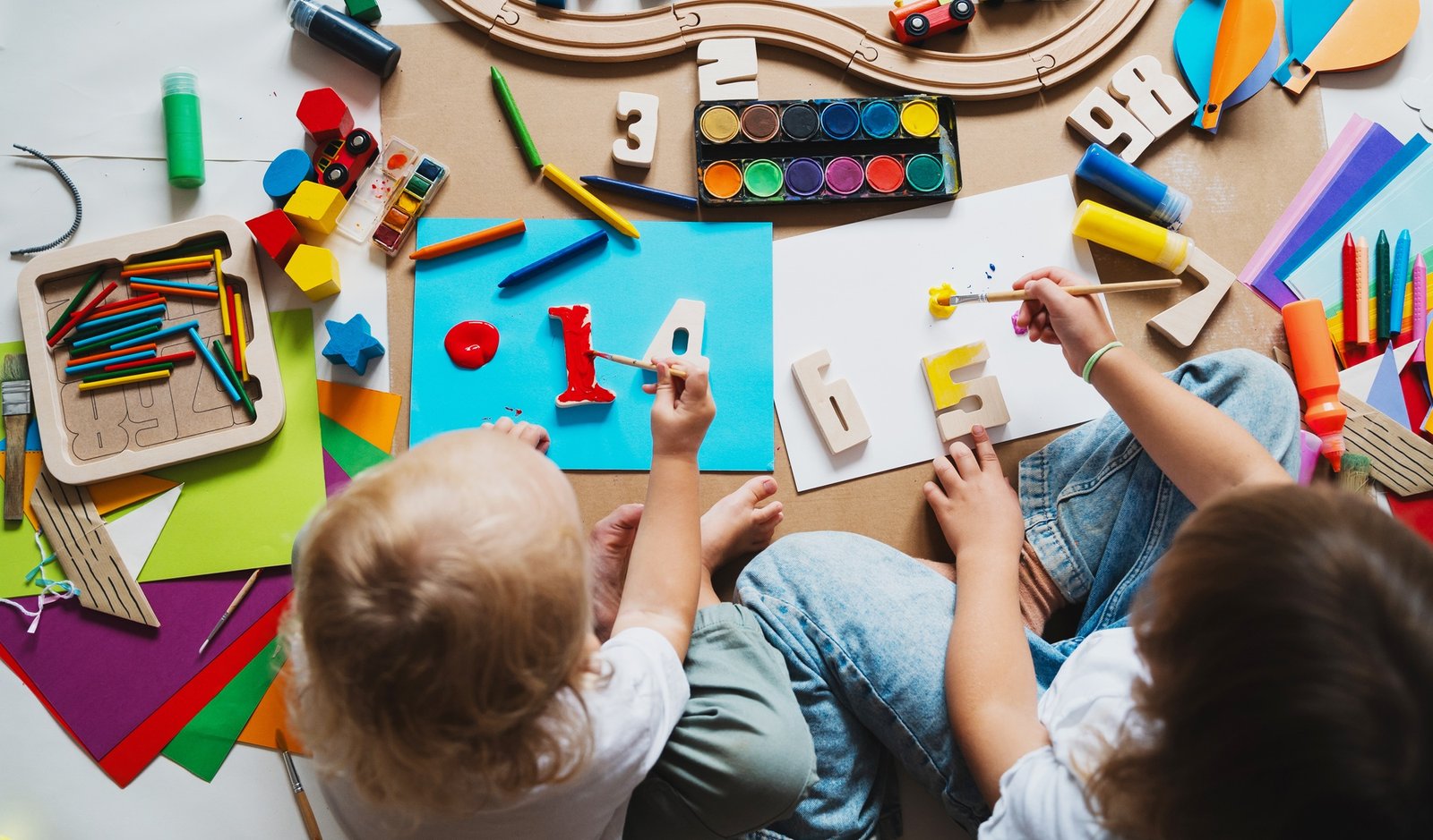 Children drawing and making crafts in kindergarten or daycare.